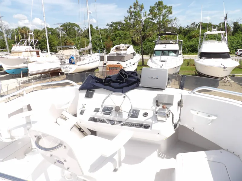 Slide: The Image of 1999 Mainship 350 Trawler helm with steering wheel and navigation equipment, docked among other boats. - 16