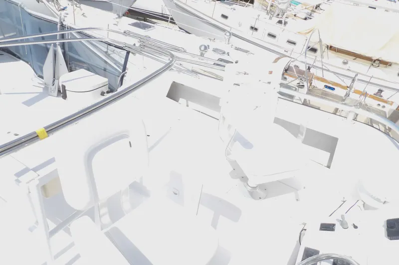 Slide: The Image of 1999 Mainship 350 Trawler deck with seating and railings in a marina. - 18