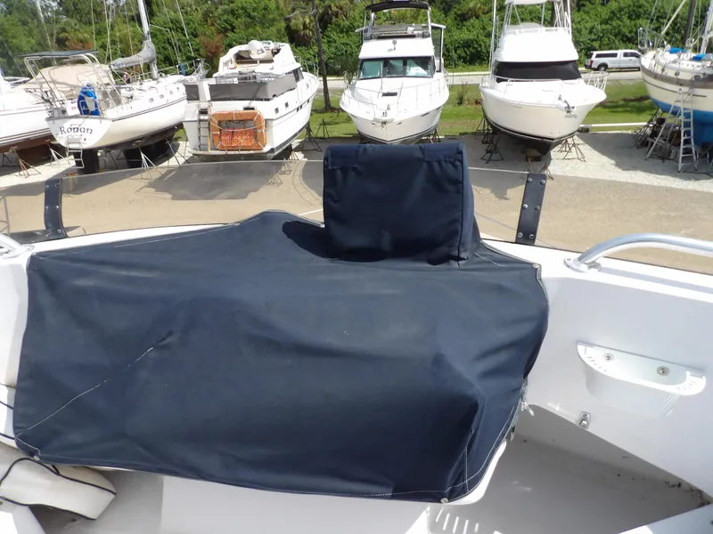 Slide: The Image of 1999 Mainship 350 Trawler with covered helm, surrounded by boats in a marina. - 24