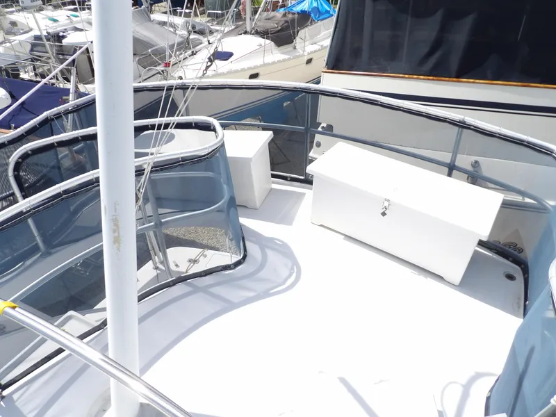 Slide: The Image of 1999 Mainship 350 Trawler deck with storage boxes and railing, docked at marina. - 27