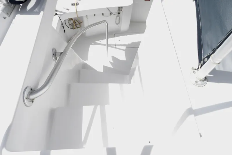 Slide: The Image of Staircase on 1999 Mainship 350 Trawler, featuring sleek white design and metal handrail. - 28