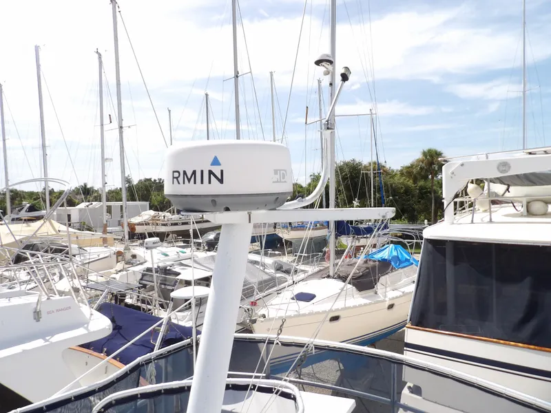 Slide: The Image of 1999 Mainship 350 Trawler in marina, surrounded by sailboats under clear sky. - 29