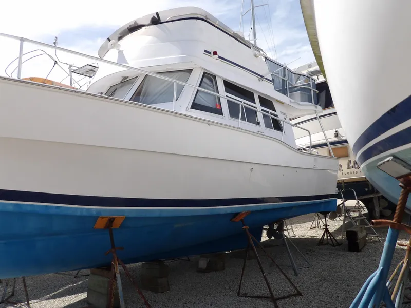 Slide: The Image of 1999 Mainship 350 Trawler on dry dock, white hull with blue bottom paint. - 3