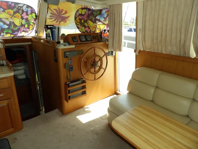 Slide: The Image of Interior of 1999 Mainship 350 Trawler with helm, seating, and floral window covers. - 32