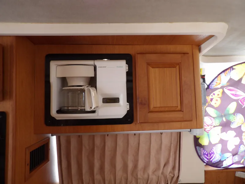 Slide: The Image of Coffee maker in 1999 Mainship 350 Trawler kitchen with wooden cabinets and butterfly curtain. - 41