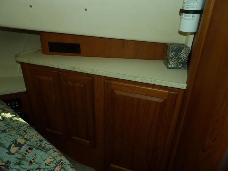 Slide: The Image of Wooden cabinetry in 1999 Mainship 350 Trawler interior, featuring a countertop and decorative box. - 49