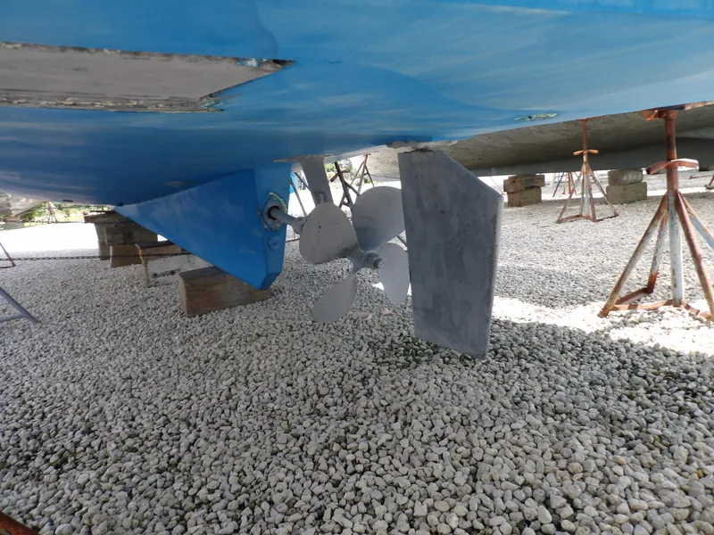 Slide: The Image of 1999 Mainship 350 Trawler propeller and rudder on gravel surface. - 9