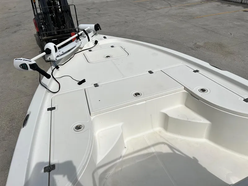 Slide: The Image of 2009 Triton 220 LTS boat deck with trolling motor, parked on concrete surface. - 15