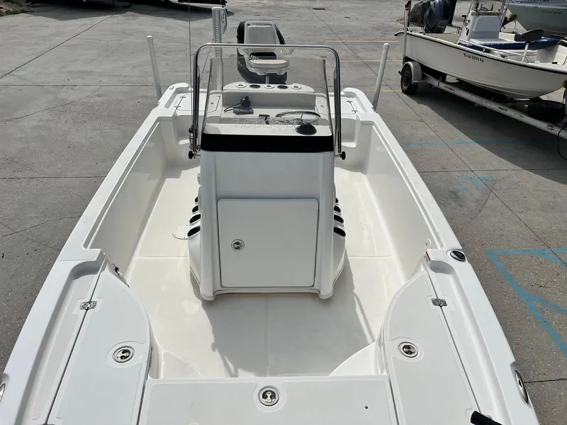 Slide: The Image of 2009 Triton 220 LTS boat, white interior, center console, parked on concrete. - 16