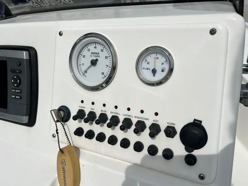 Slide: The Image of 2009 Triton 220 LTS boat dashboard with RPM and fuel gauges, switches, and controls. - 6