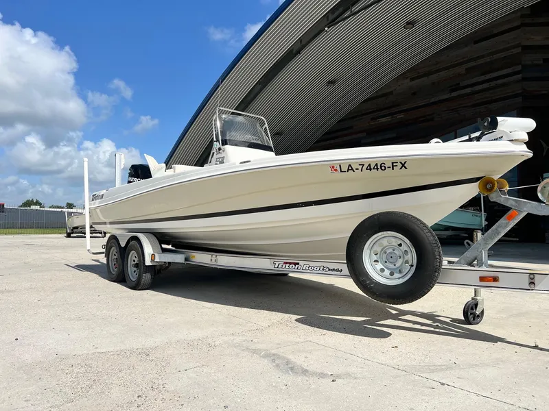 Slide: The Image of 2009 Triton 220 LTS boat on trailer outside a large building. - 9