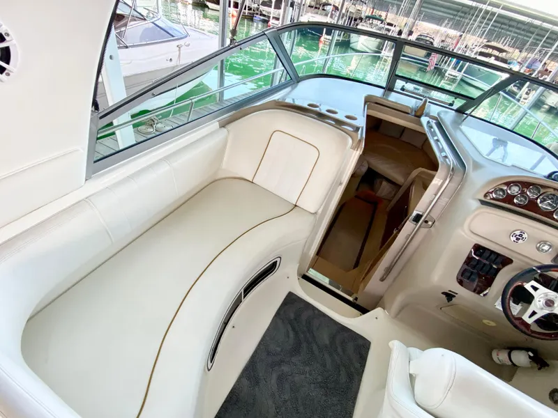 Slide: The Image of 2001 Sea Ray 290 Sundancer boat interior with white seating and helm. - 22