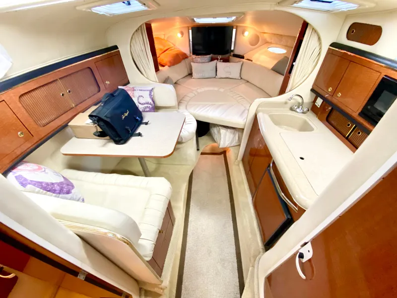 Slide: The Image of Interior of 2001 Sea Ray 290 Sundancer yacht with cozy seating and kitchenette. - 25