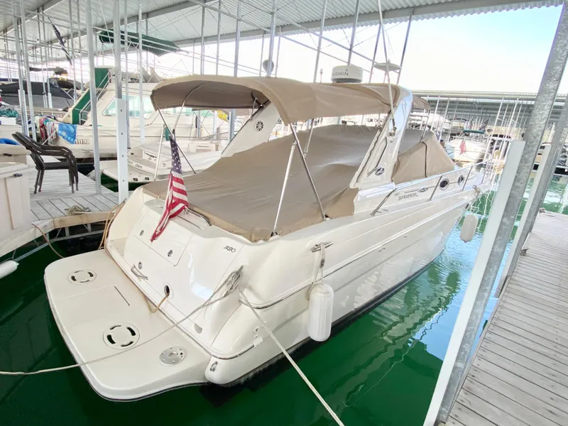 Slide: The Image of 2001 Sea Ray 290 Sundancer docked in marina, covered with beige canopy. - 28
