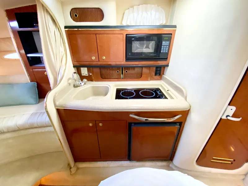 Slide: The Image of 2001 Sea Ray 290 Sundancer galley with microwave, stove, and sink. - 7