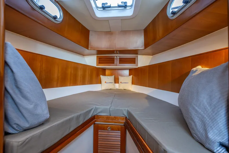 Slide: The Image of Cozy cabin interior of 2024 SeaPiper 37 boat with wood accents and cushions. - 14