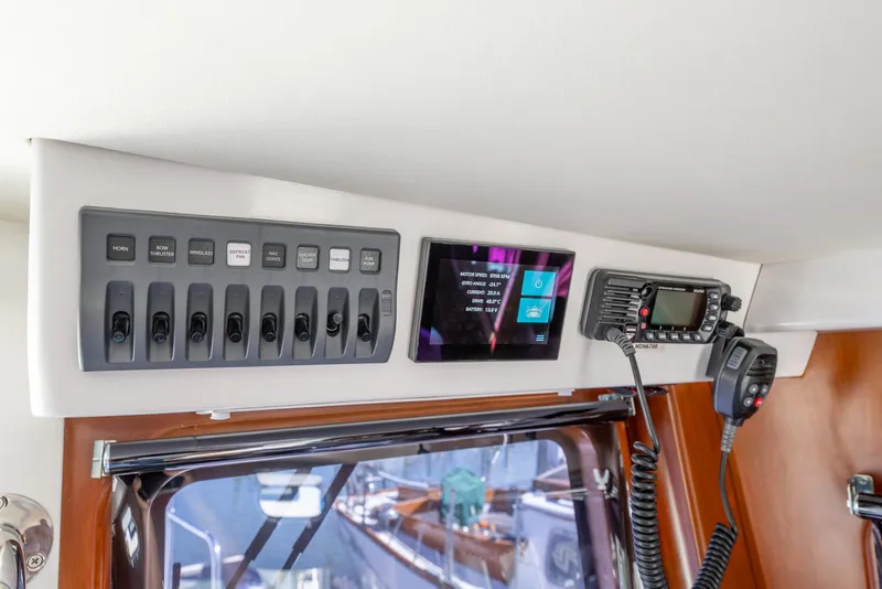 Slide: The Image of Control panel of 2024 SeaPiper 37 boat with switches and communication devices. - 17