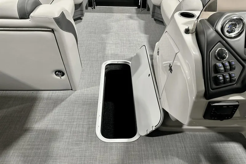 Slide: The Image of 2025 Sylvan L-5 boat interior with open storage compartment and control panel. - 22