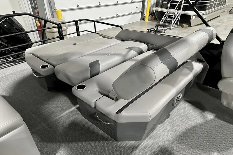 Slide: The Image of 2025 Sylvan L-5 boat interior with gray seating and cup holders in a showroom. - 28