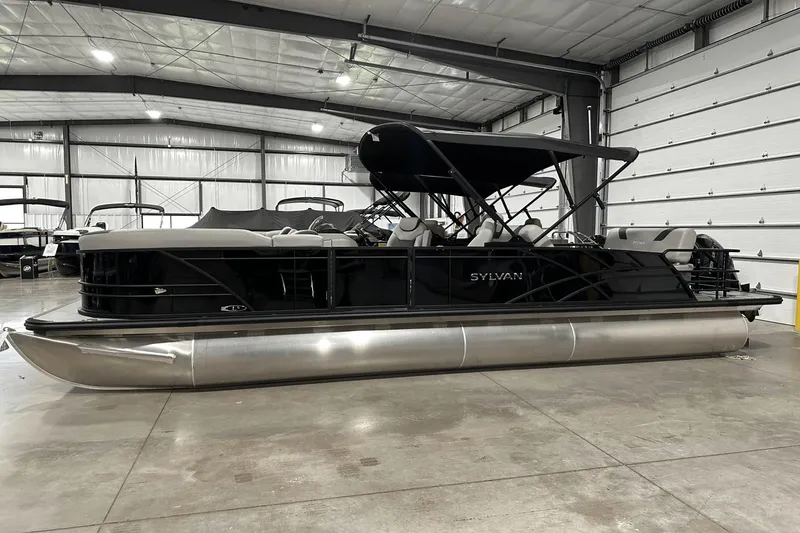 Slide: The Image of 2025 Sylvan L-5 pontoon boat in a spacious indoor showroom. - 5