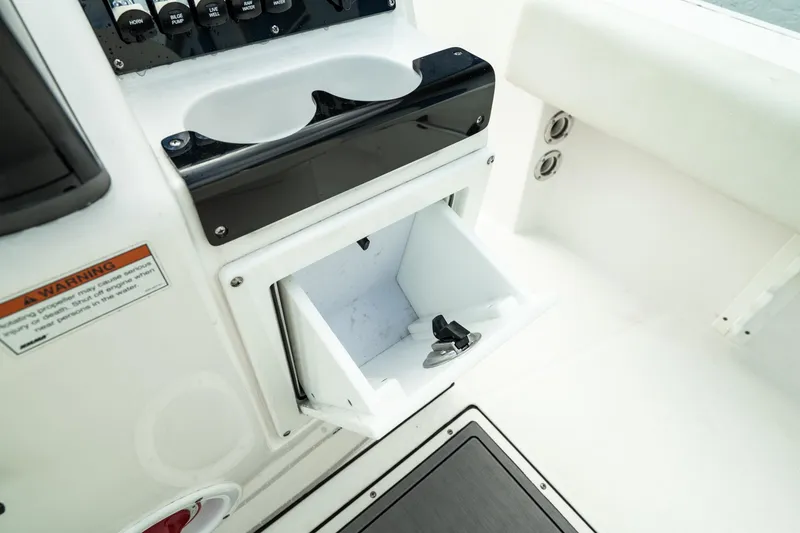 Slide: The Image of 2023 Edgewater 188CC boat console with open storage compartment and cup holders. - 24
