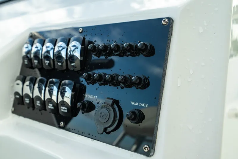 Slide: The Image of Control panel of 2023 Edgewater 188CC boat with switches and trim tabs. - 26
