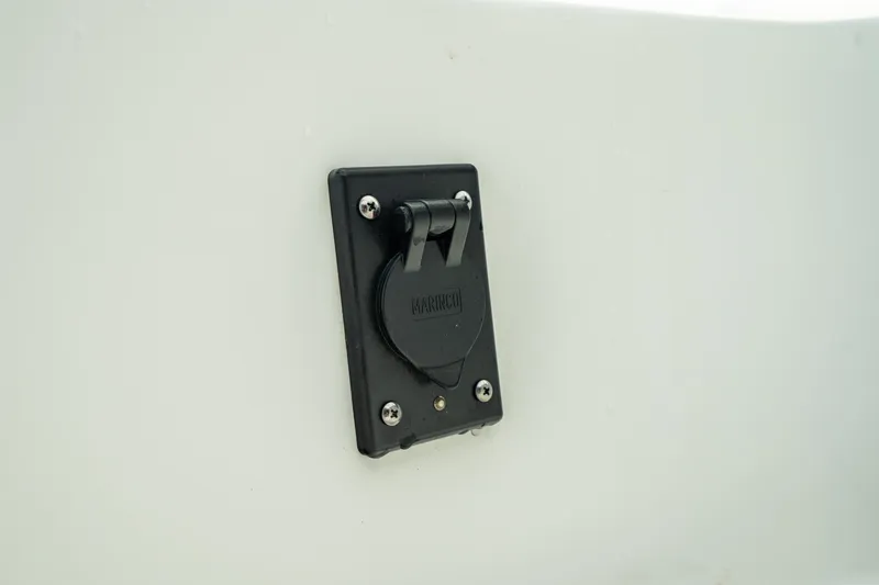 Slide: The Image of 2023 Edgewater 188CC boat detail showing a black electrical outlet on a white surface. - 31