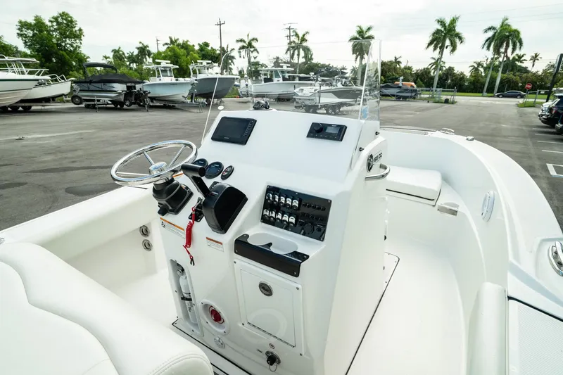 Slide: The Image of 2023 Edgewater 188CC boat interior with steering console and controls in a marina setting. - 32