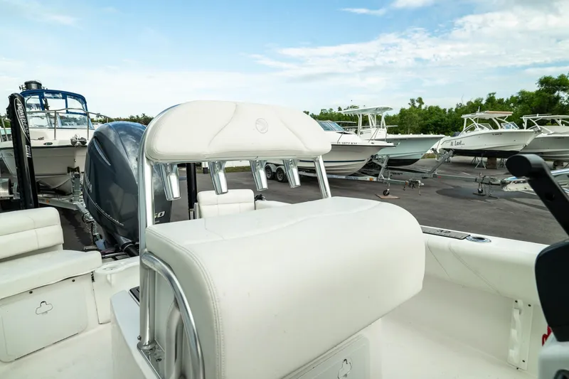 Slide: The Image of 2023 Edgewater 188CC boat interior with white seating, docked among other boats. - 6