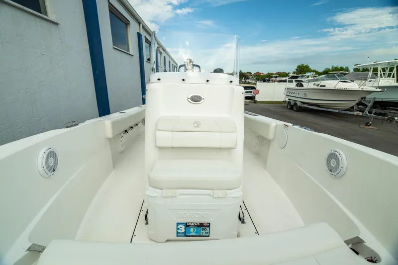 Slide: The Image of 2023 Edgewater 188CC boat interior with seating and storage, docked outdoors. - 8