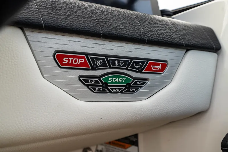 Slide: The Image of Control panel of 2022 Nautique Super Air Nautique G23 boat with start and stop buttons. - 12