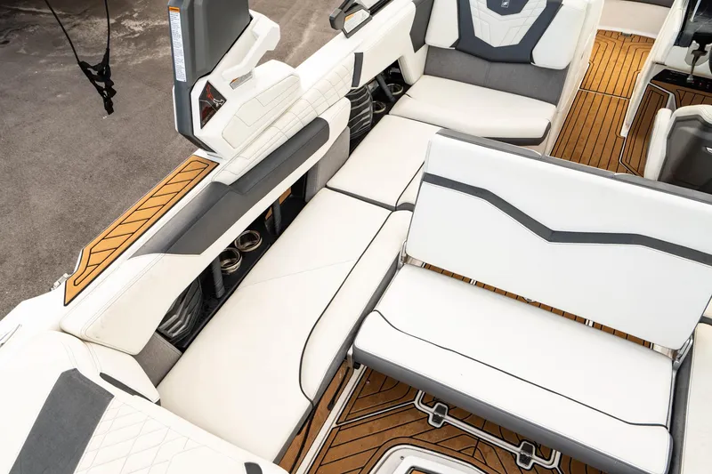 Slide: The Image of 2022 Nautique Super Air Nautique G23 interior with white seating and teak flooring. - 18