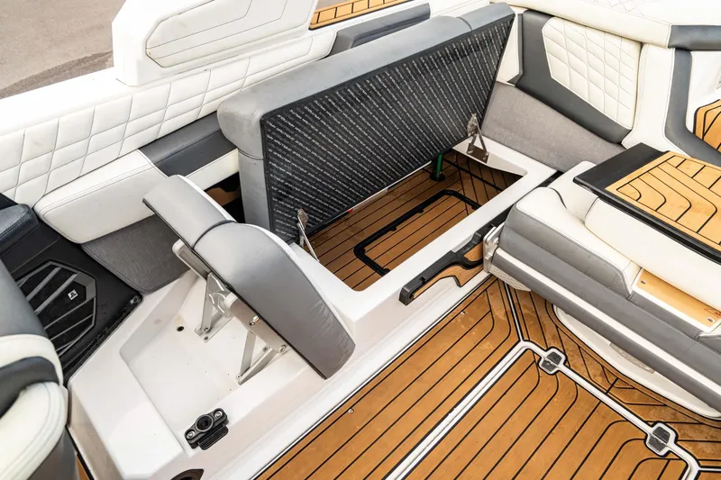 Slide: The Image of 2022 Nautique Super Air Nautique G23 interior with open storage compartment and luxury seating. - 24