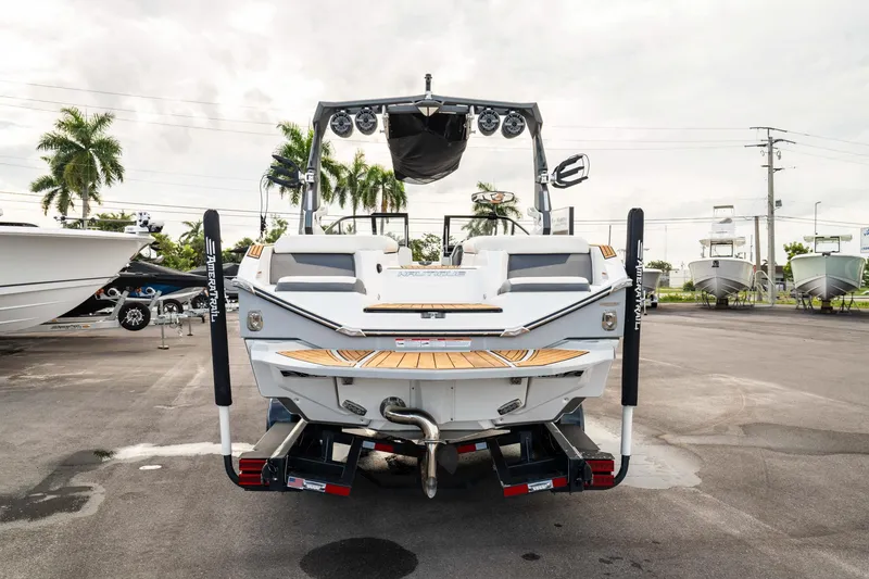 Slide: The Image of 2022 Nautique Super Air Nautique G23 boat rear view in a marina setting. - 42