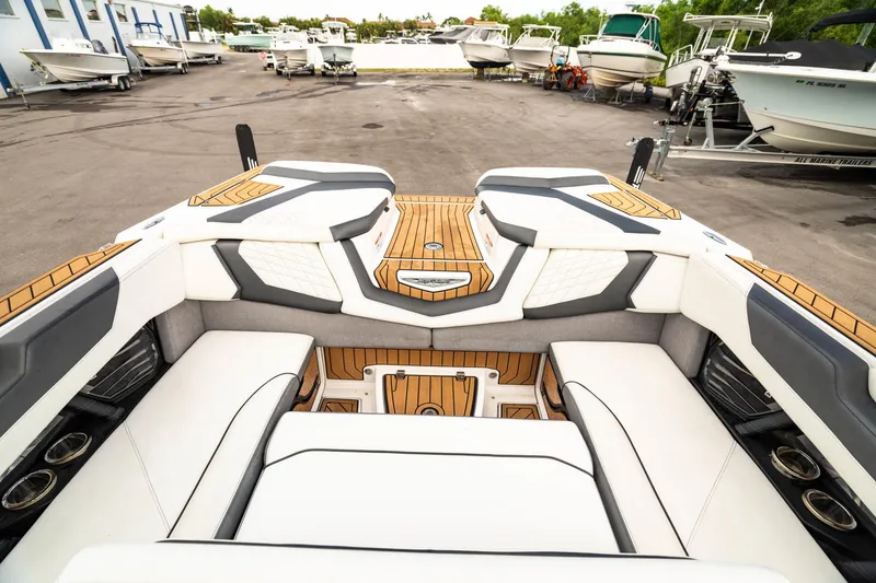 Slide: The Image of 2022 Nautique Super Air Nautique G23 interior with luxurious seating and teak flooring. - 7