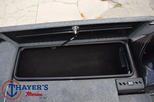 Slide: The Image of 2020 Triton 20 TRX Patriot boat storage compartment, open lid, Thayer's Marine logo visible. - 18