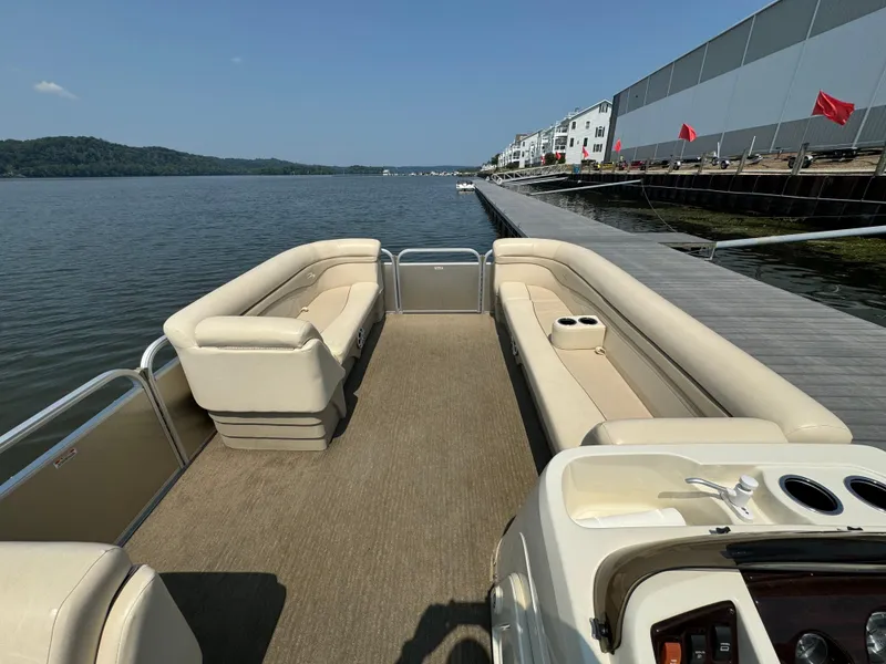 Slide: The Image of 2014 Bennington 24 SLX3 pontoon boat with spacious seating, docked by a scenic waterfront. - 17