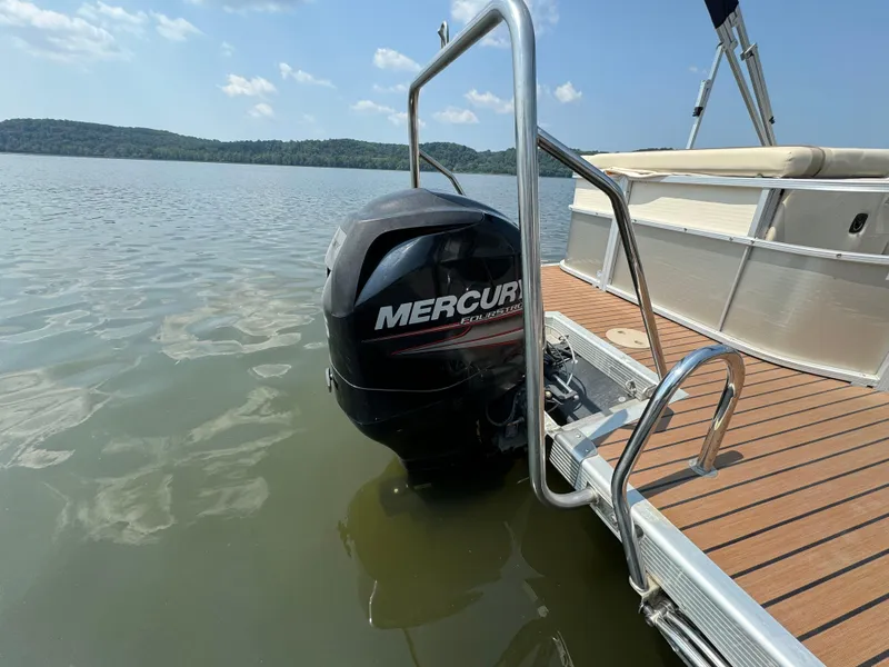 Slide: The Image of 2014 Bennington 24 SLX3 pontoon boat with Mercury outboard motor on a calm lake. - 4