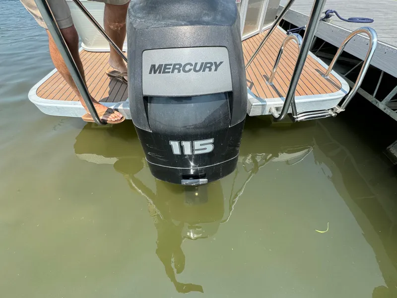 Slide: The Image of Outboard motor on 2014 Bennington 24 SLX3 pontoon boat, docked in calm water. - 6