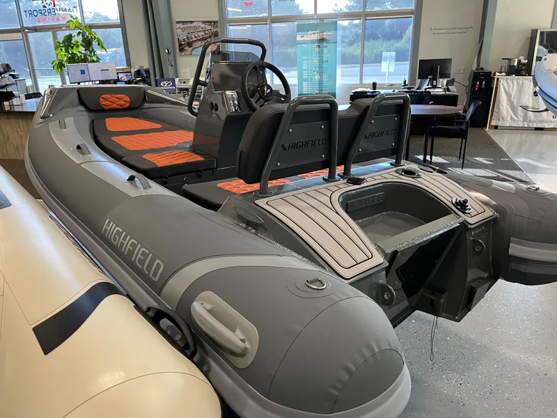 The Image of 2024 Highfield Sport 360 inflatable boat with orange seating in showroom. - 0