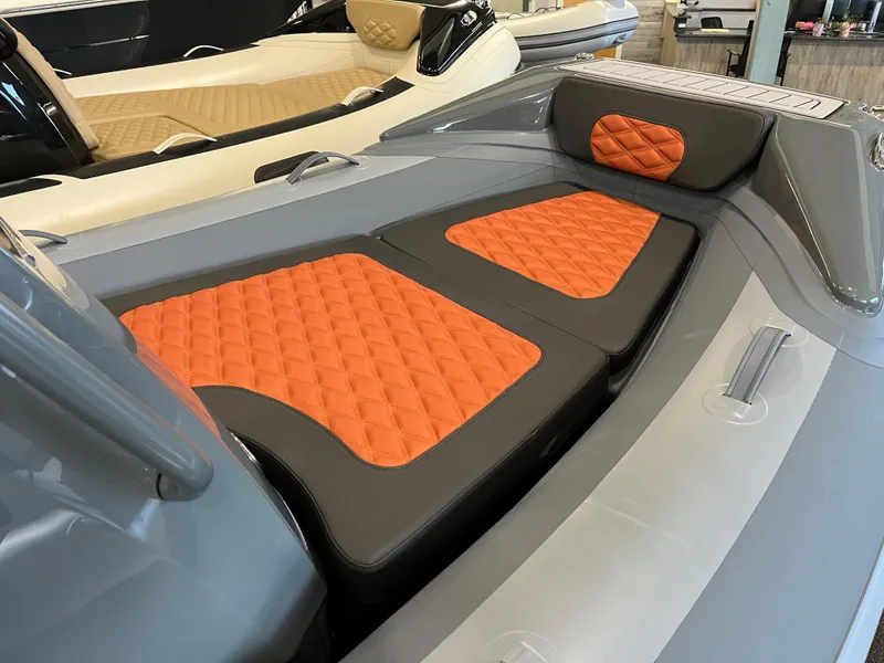 Slide: The Image of 2024 Highfield Sport 360 boat with orange quilted seating and sleek gray design. - 2