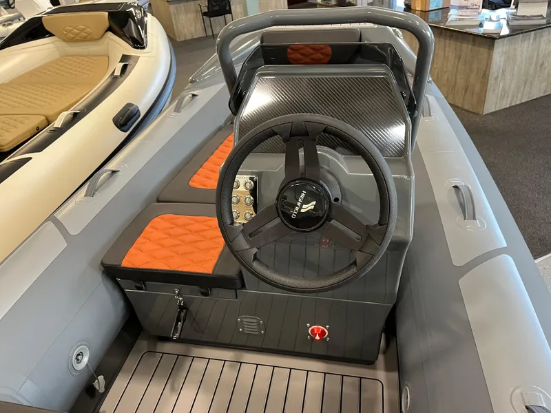 Slide: The Image of 2024 Highfield Sport 360 boat interior with steering wheel and orange seats. - 4