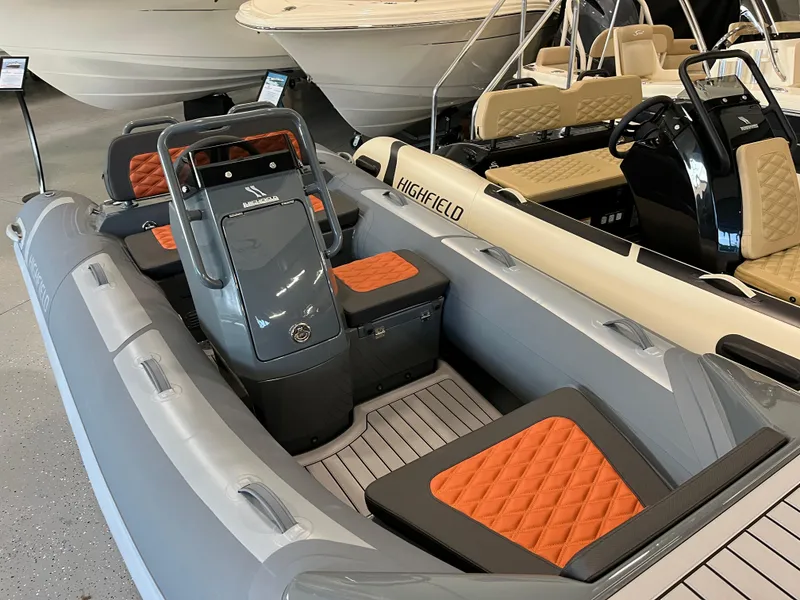 Slide: The Image of 2024 Highfield Sport 360 boat with orange seats, displayed in a showroom. - 7
