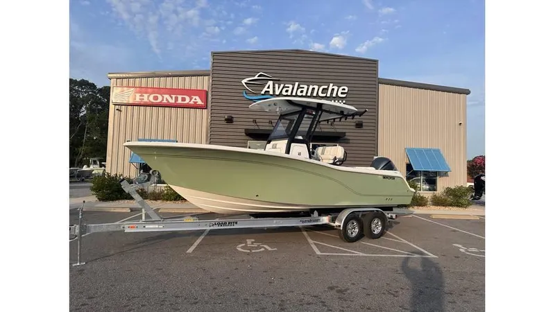 The Image of 2025 Sea Fox 248 Commander boat on trailer outside dealership with Honda and Avalanche signs. - 0