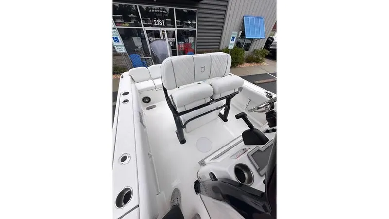 Slide: The Image of 2025 Sea Fox 248 Commander boat interior with seating and console, displayed outdoors. - 19