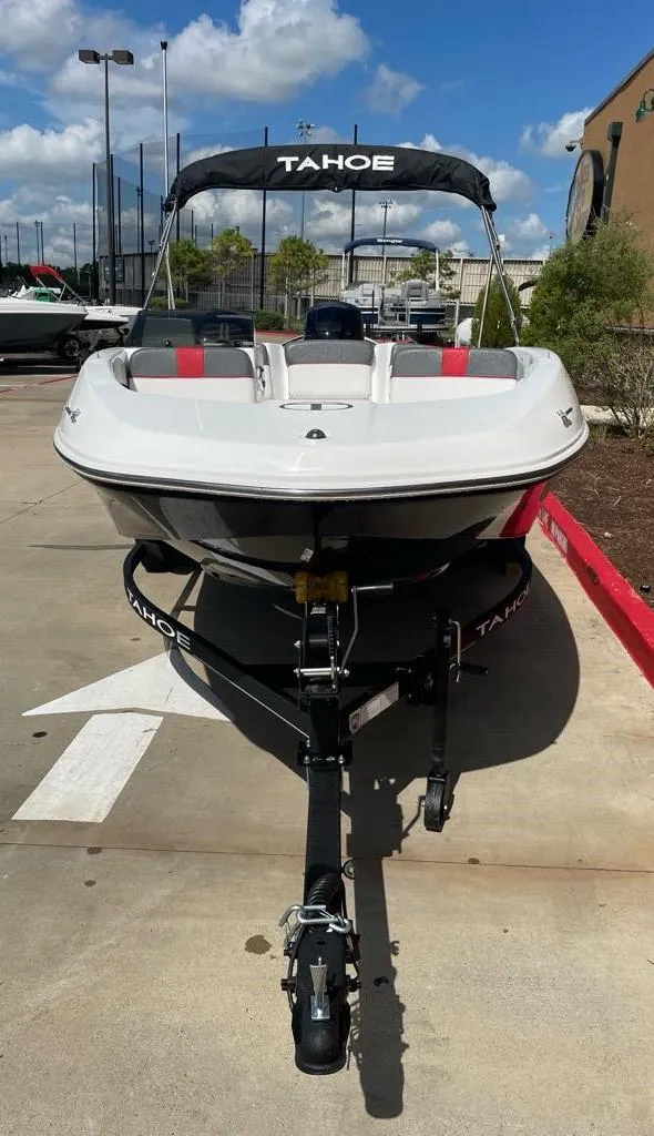 Slide: The Image of 2024 Tahoe T16 boat on trailer, parked outdoors under a clear blue sky. - 1