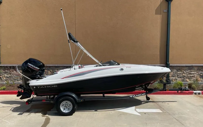 Slide: The Image of 2024 Tahoe T16 boat with Mercury engine on a trailer, parked outdoors. - 2