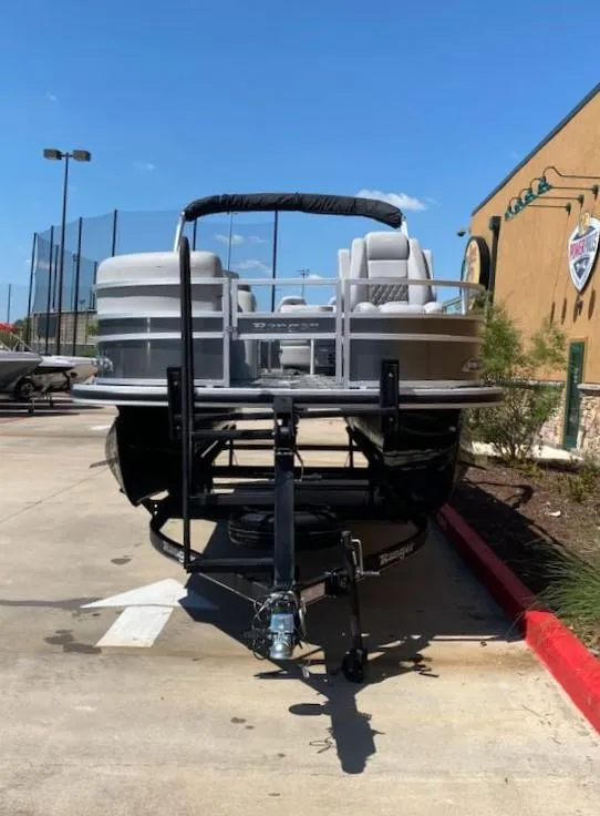 Slide: The Image of 2024 Ranger Reata 220FC pontoon boat on trailer in parking lot. - 1