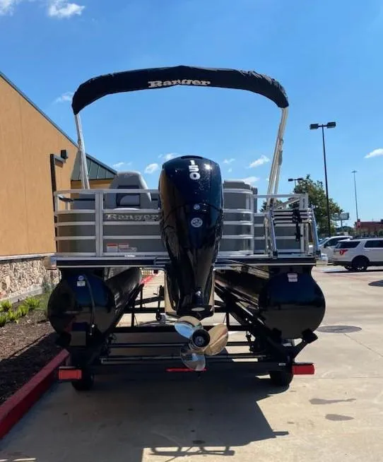 Slide: The Image of 2024 Ranger Reata 220FC pontoon boat with outboard motor, parked outdoors. - 3
