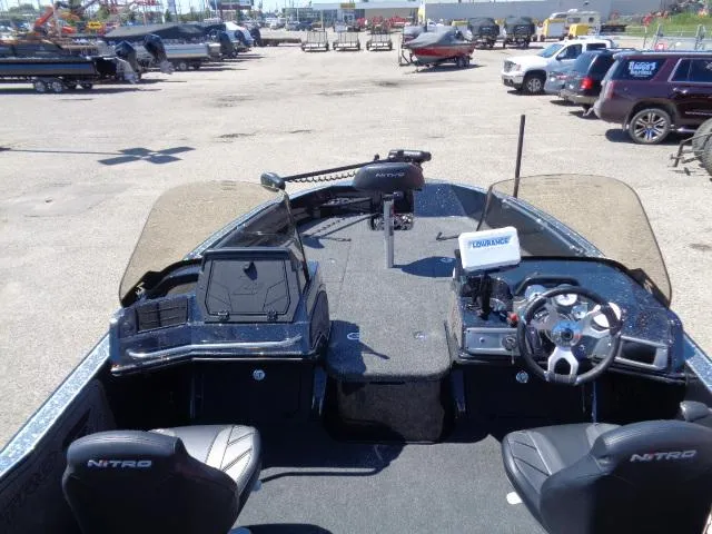Slide: The Image of 2024 Nitro ZV20 boat interior with steering wheel and seating in a parking lot. - 6